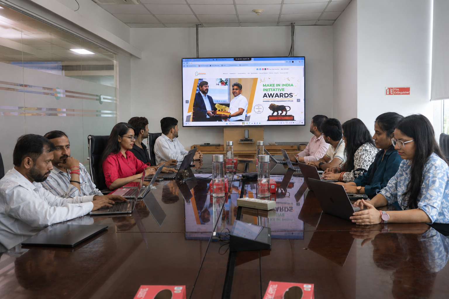 Team collaborating on laptops around a boardroom table