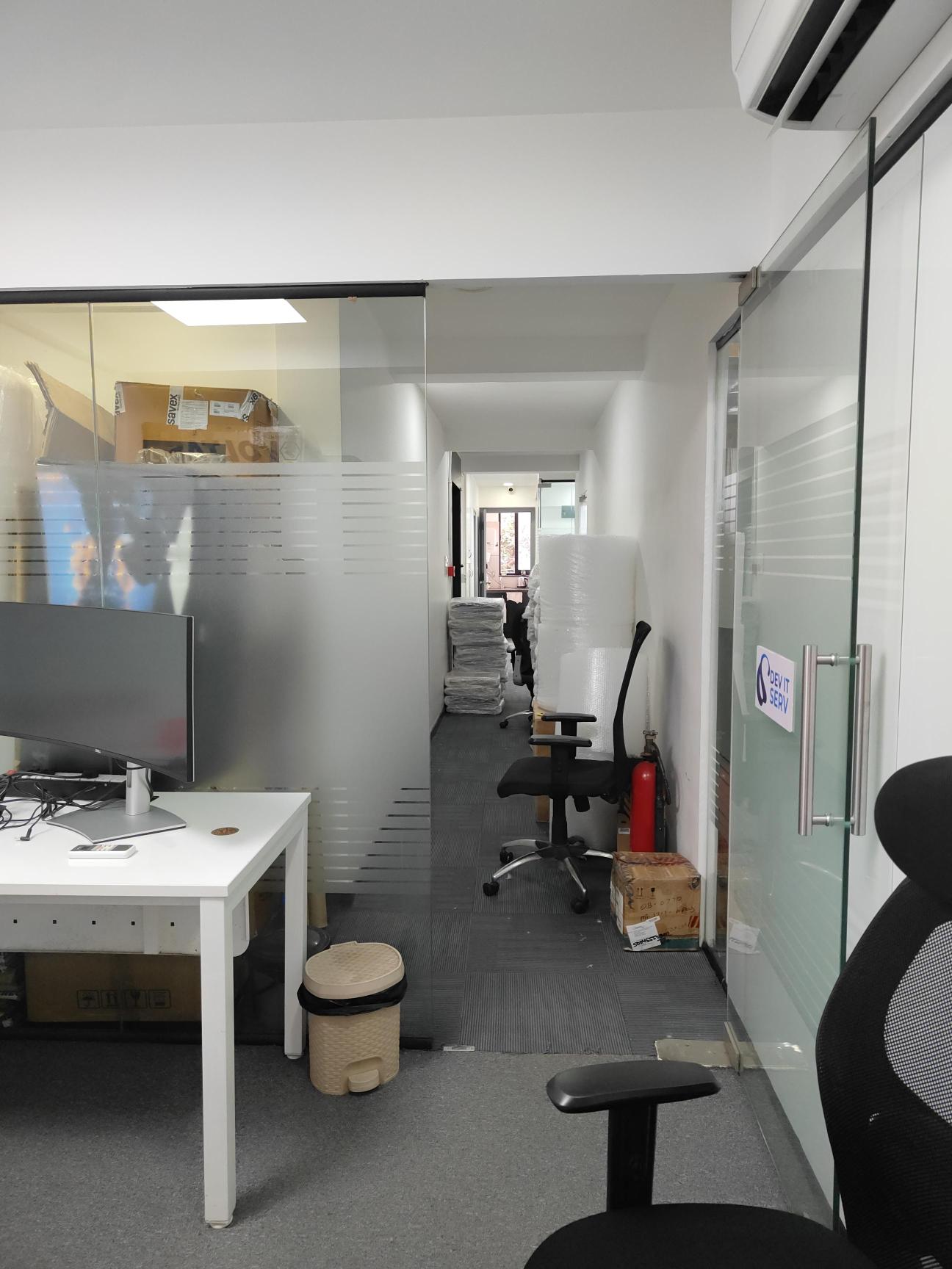 Dev IT Serv office corridor with glass meeting rooms and technology equipment